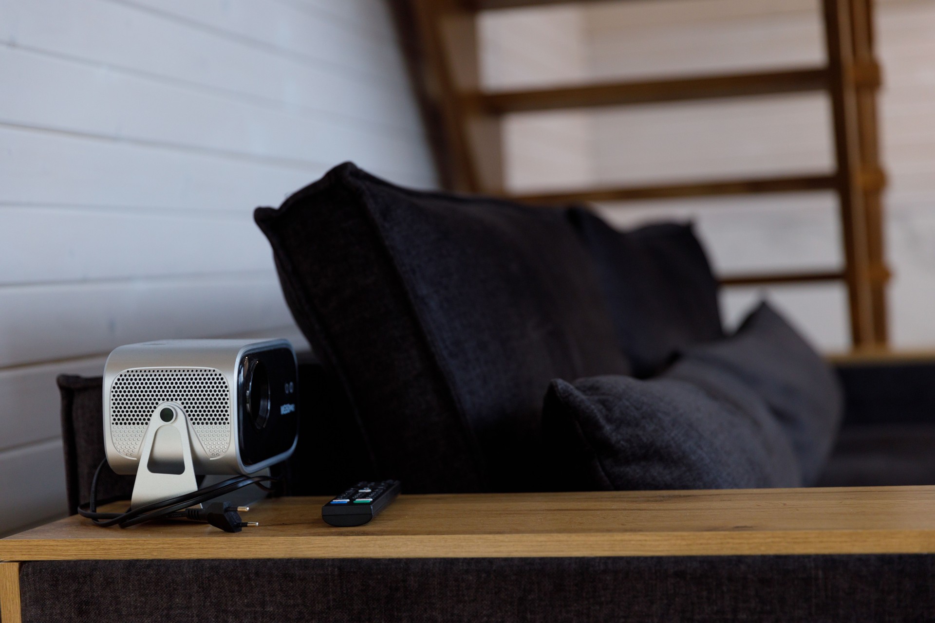 Modern Living Space Featuring a Cozy Couch and a Sleek Projector Perfect for Movie Nights and Home Entertainment Settings with Stylish Aesthetics.